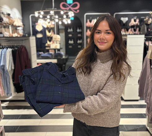 Medarbejder fremviser mørkeblå sæt nattøj